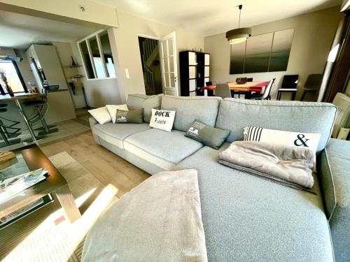 un salon avec un canapé bleu avec des oreillers dans l'établissement Villa Spacieuse & Moderne, Proche des Plages, à Saint-Briac-sur-Mer