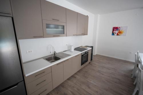 a kitchen with white cabinets and a sink at Villas Magnolia in Blagaj