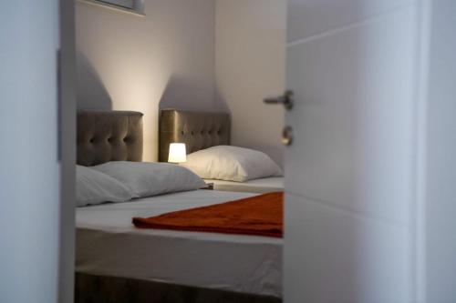 a bedroom with two beds with white sheets and pillows at Villas Magnolia in Blagaj