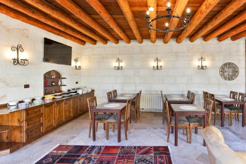 una grande sala da pranzo con tavoli e sedie in legno di Hotel Asia Minor a Ürgüp
