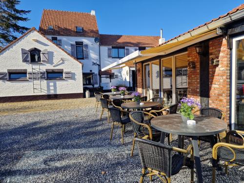 a row of tables and chairs on a patio at B&B De Kroonhoeve in Beringen
