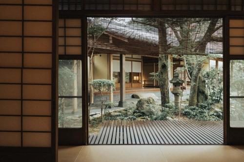 a door to a building with a garden outside at Arima Onsen Tocen Goshobo in Kobe