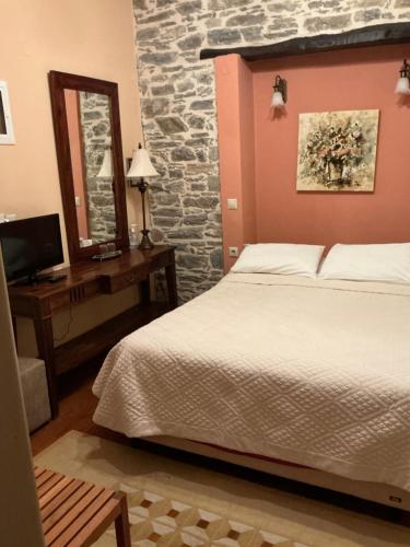 a bedroom with a bed and a desk and a mirror at Αρχοντικό Πρεπάλα in Neochori