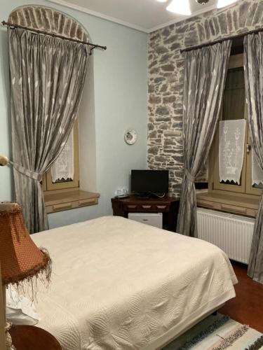a bedroom with a bed and a stone wall at Αρχοντικό Πρεπάλα in Neochori