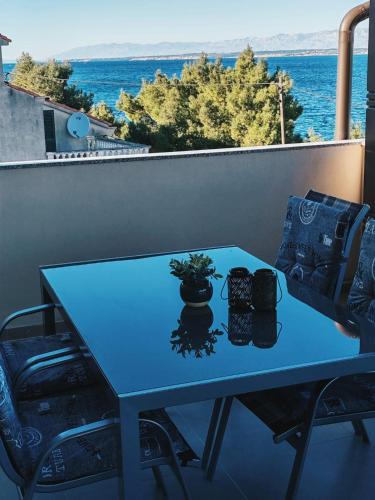 a blue table on a balcony with a view of the ocean at Azure Apartment in Kali