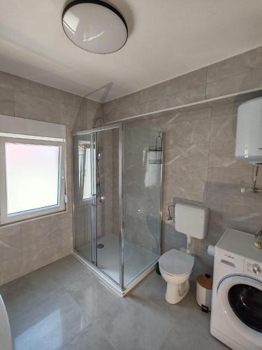 a bathroom with a shower and a toilet and a sink at Azure Apartment in Kali