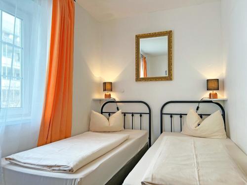 two beds in a room with a mirror and a window at Hotel Mariahilf München in Munich
