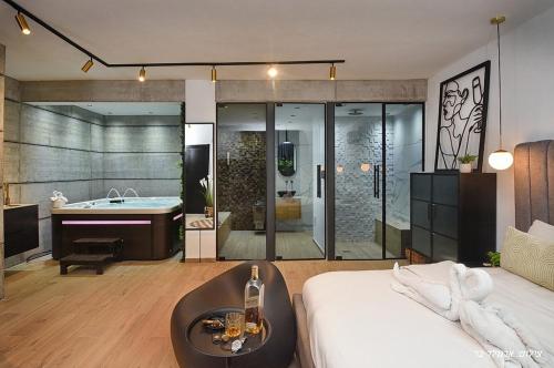 a bedroom with a tub and a bed and a sink at סוויטות בל - סוויטות יוקרה עם בריכה פרטית in Safed