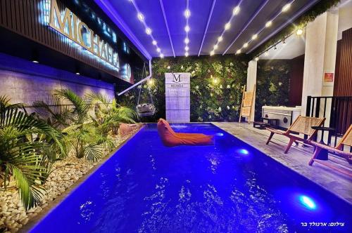 a swimming pool with blue water in a building at סוויטות בל - סוויטות יוקרה עם בריכה פרטית in Safed