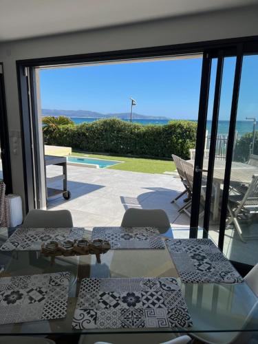 d'une terrasse avec une table en verre et une vue sur l'océan. dans l'établissement Villa Récampado Les pieds dans l'eau avec piscine, à Cavalaire-sur-Mer