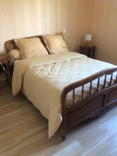 un grand lit dans une chambre avec un plancher en bois dans l'établissement La Maison Amayla vous accueille, à Saint-Priest-des-Champs