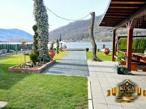 a walkway next to a house next to a lake at Kuca za odmor Stakic in Zvornik