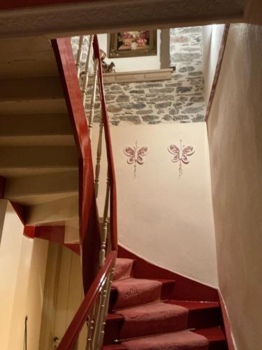 a staircase with red steps with butterflies painted on the wall at Αρχοντικό Πρεπάλα in Neochori