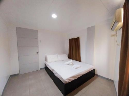a bedroom with a white bed and a window at Abode86 Transient-Agus in Lapu Lapu City