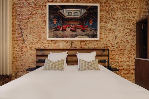 a large white bed with pillows in a room at Adam's Canal House in Amsterdam