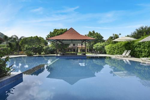 a swimming pool with a gazebo and a house at Anandam - A Luxury Resort in Udaipur in Udaipur