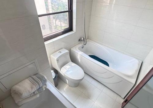 a bathroom with a tub and a toilet and a sink at Les Lavandins-Yaoundé in Yaoundé