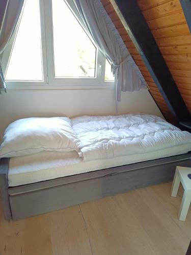 a bed in a room with a window at Ferienhaus Freilingen in Blankenheim