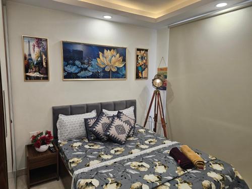 a bedroom with a bed and some pictures on the wall at Ultra Luxury 1Bhk 1121 Flat By Bliss Stay in Ghaggar