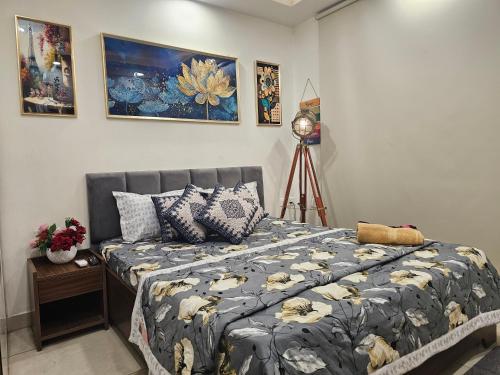 a bedroom with a bed with a blue comforter at Ultra Luxury 1Bhk 1121 Flat By Bliss Stay in Ghaggar