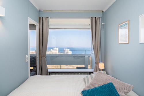 a bedroom with a bed and a view of the ocean at Panoramic Sierksdorf App A12-1 in Sierksdorf