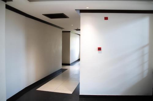an empty hallway with white walls and a door at SV Grand in Mettuppālaiyam