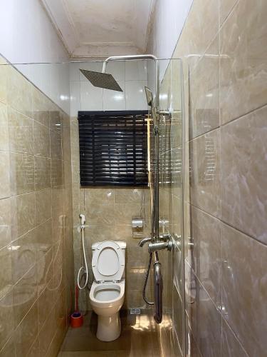 a bathroom with a toilet and a shower at DingãBell ApartHotel in Ikeja