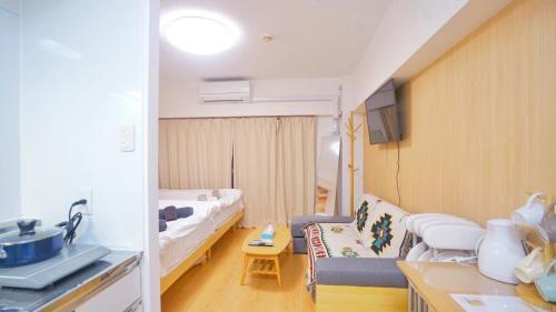 a small living room with a couch and a bed at TOKYO ICHIBAN SHINJUKU in Tokyo