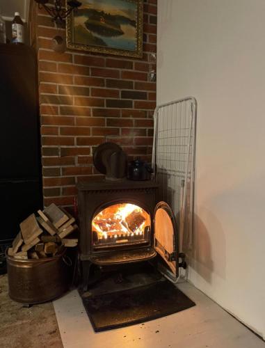 a fireplace in a room with a brick wall at MOJITO`s ROOM in Lorenskog