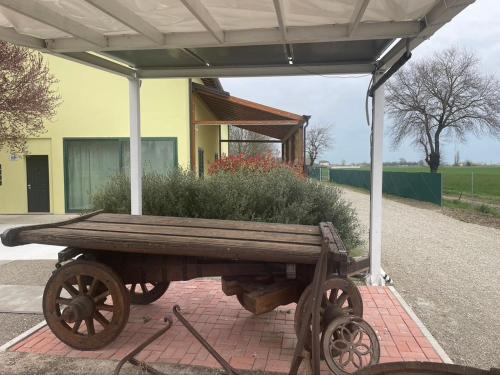 a wooden cart with a planter on the side of a building at La Barca di Grano in SantʼAgata Bolognese