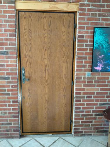 a brown wooden door in a brick wall at Håstrups Natur Perle in Fåborg