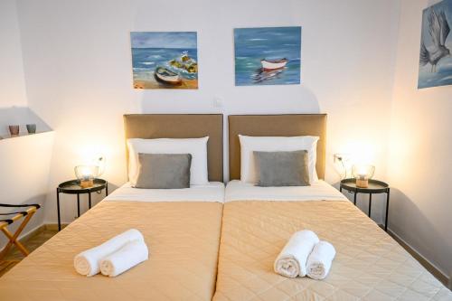 a bedroom with a bed with two towels on it at 3 Goddesses' studios in Koukounaries