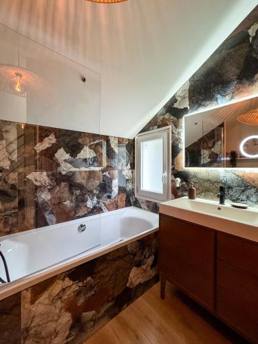 une salle de bain avec une baignoire et un lavabo dans l'établissement Studio Indépendant, à Ouistreham