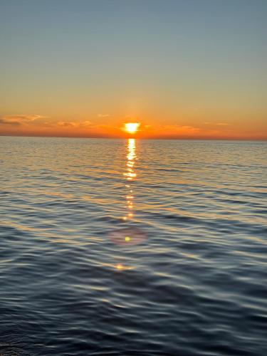 a sunset over the water with the sun setting at Drin's Seaside Apartment in Kavajë