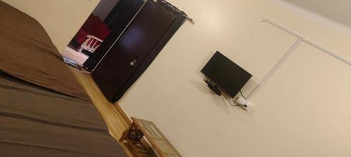 a tv on a wall in a room at Kusum Palace in Varanasi