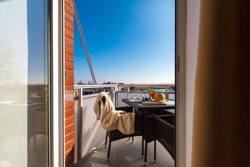 a balcony with a table and chairs and a view at Hotel Boddenhus Garni in Zingst