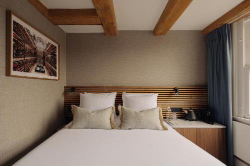a bedroom with a large bed and a window at Adam's Canal House in Amsterdam