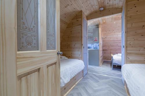 a bedroom with two beds in a wooden cabin at The Lodge at Brambles Farm in Upper Hulme