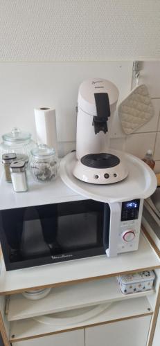 une cafetière blanche posée sur un micro-ondes dans l'établissement Le cent cinq, à Vichy