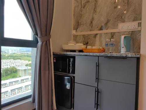 a kitchen with a counter and a window at Near Airport K Avenue Homestay by MINO Suites in Donggongon