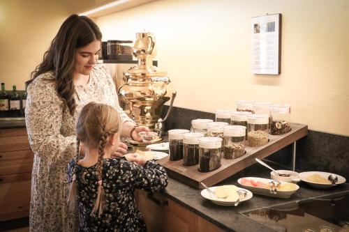 a woman and a child in a kitchen preparing food at Schloss Kapfenstein in Kapfenstein