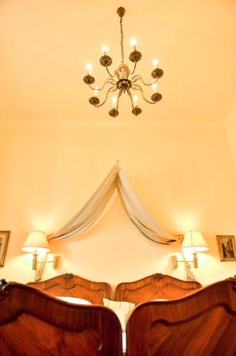 a bedroom with a bed with a chandelier at Schloss Kapfenstein in Kapfenstein
