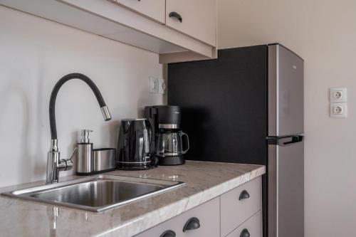 a kitchen with a sink and a refrigerator at Cuckoos House in Aegina Town