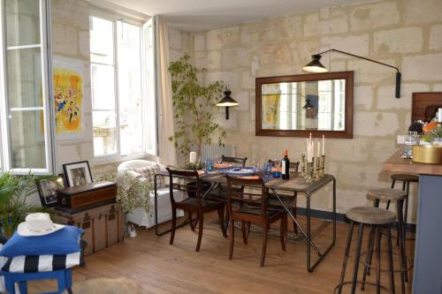 a living room with a dining room table and chairs at Charmant Appartement Avec Terrasse in Bordeaux