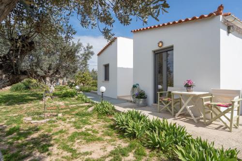 a white house with a patio and a table at Cuckoos House in Aegina Town