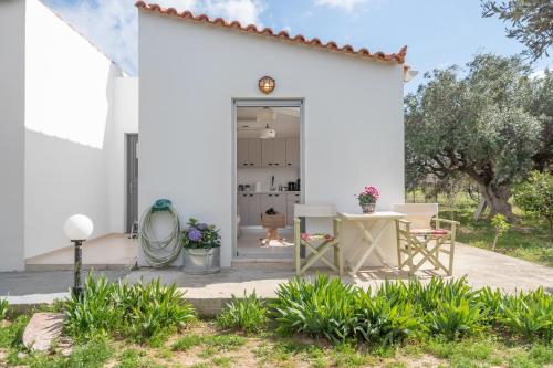 a white house with a table and chairs at Cuckoos House in Aegina Town