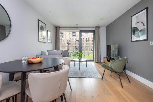 a living room with a table and chairs at Montana Apartment - Modern Comfort & Prime Location in London