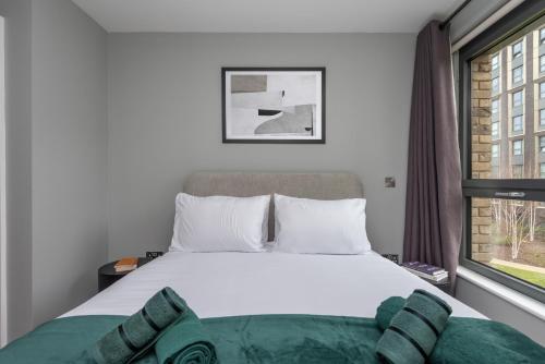 a bedroom with a white bed and a window at Montana Apartment - Modern Comfort & Prime Location in London