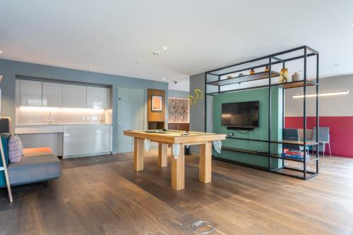 a living room with a wooden table and a shelf at Montana Apartment - Modern Comfort & Prime Location in London
