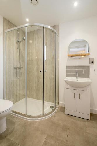 a bathroom with a shower and a toilet and a sink at 5 Oakes Court in Thorpeness